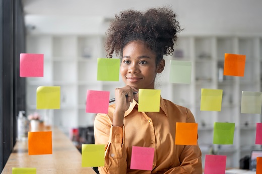 A scientist preparing sticky notes to create conference presentation slide sequence