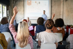 Audience of a scientific conference rising hands 